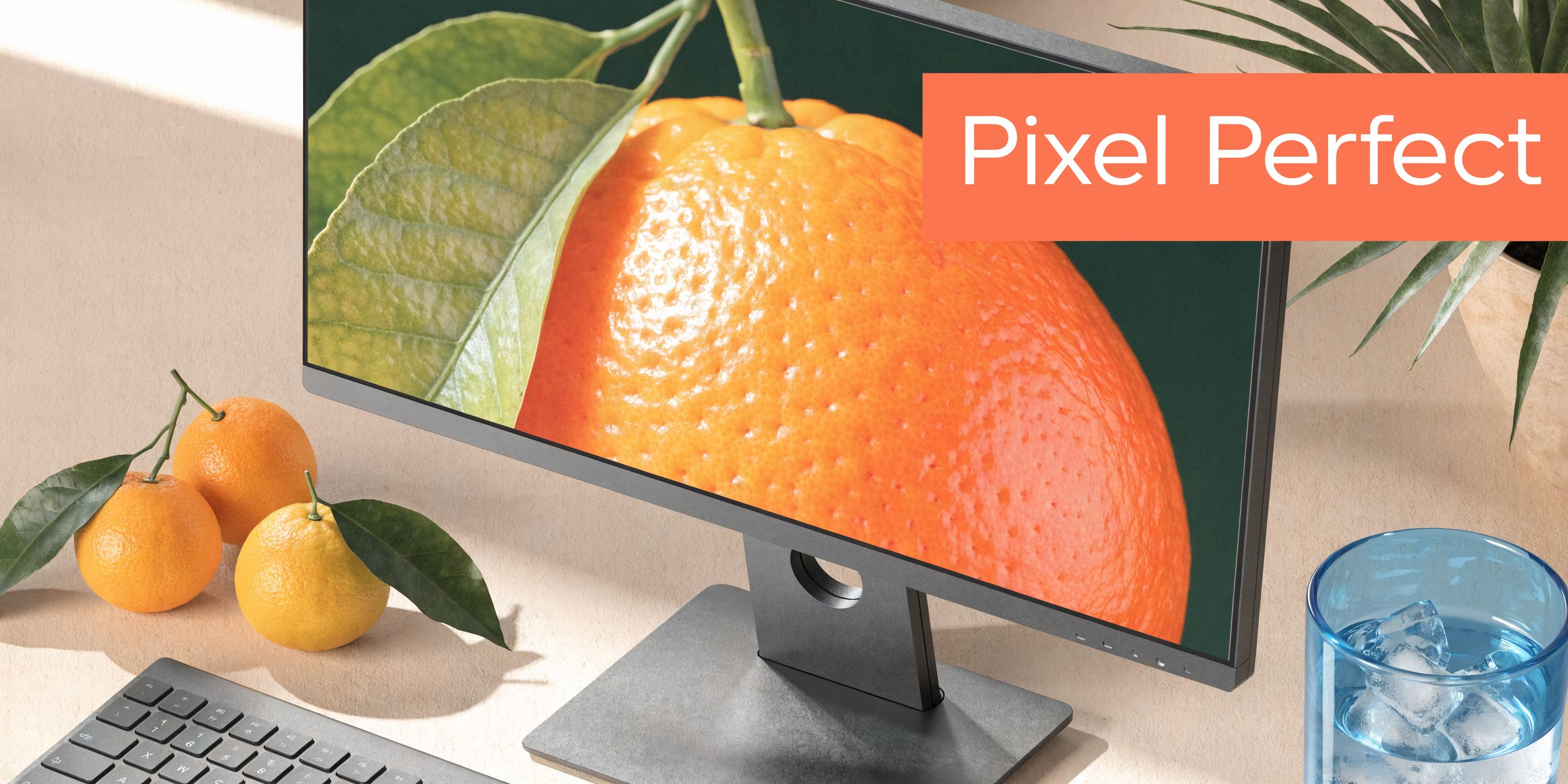 A sleek computer monitor displaying a vibrant orange close-up next to fresh oranges on a desk.