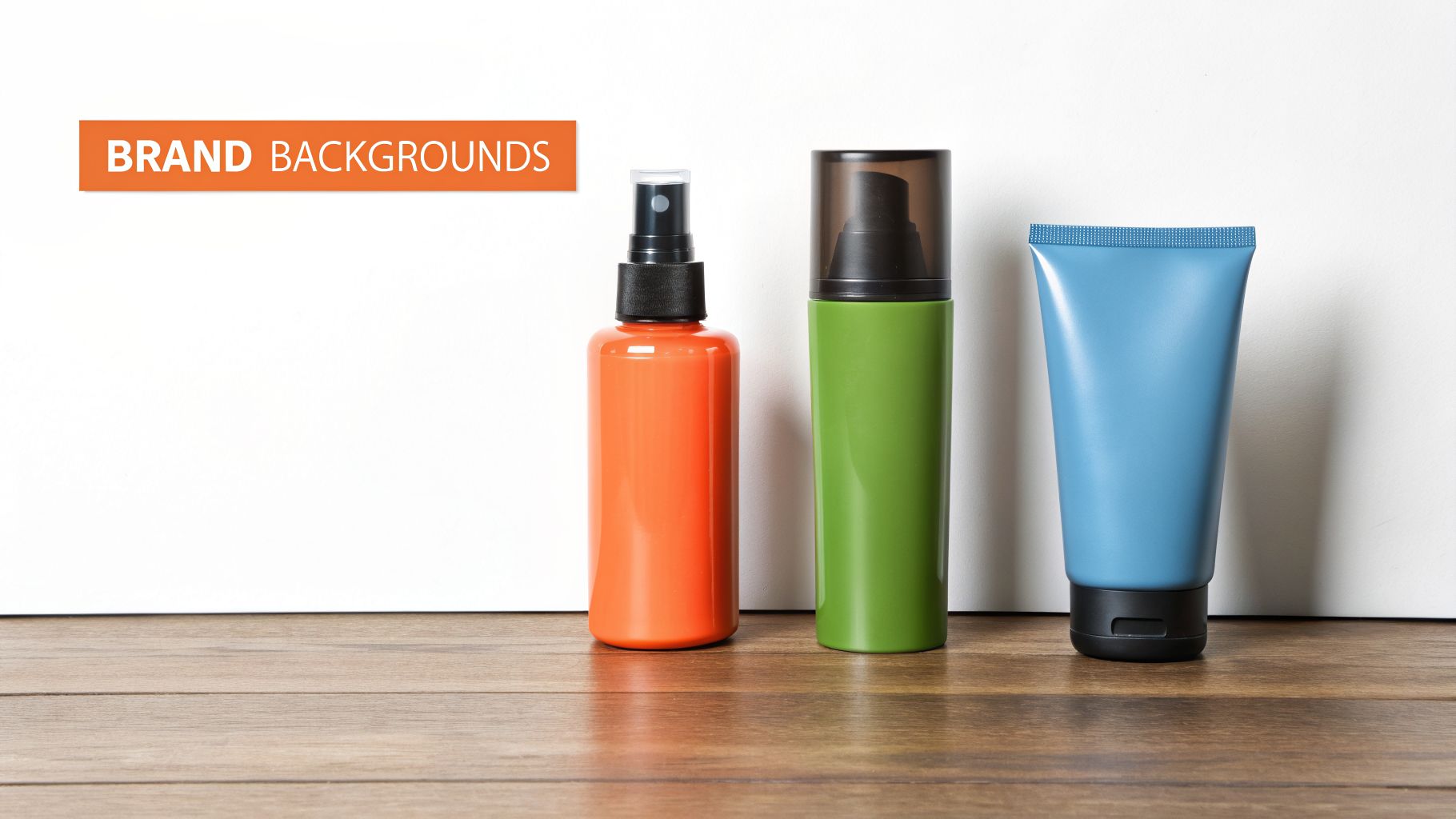 Three colorful brand product containers: an orange spray, green pump, and blue tube on wood.