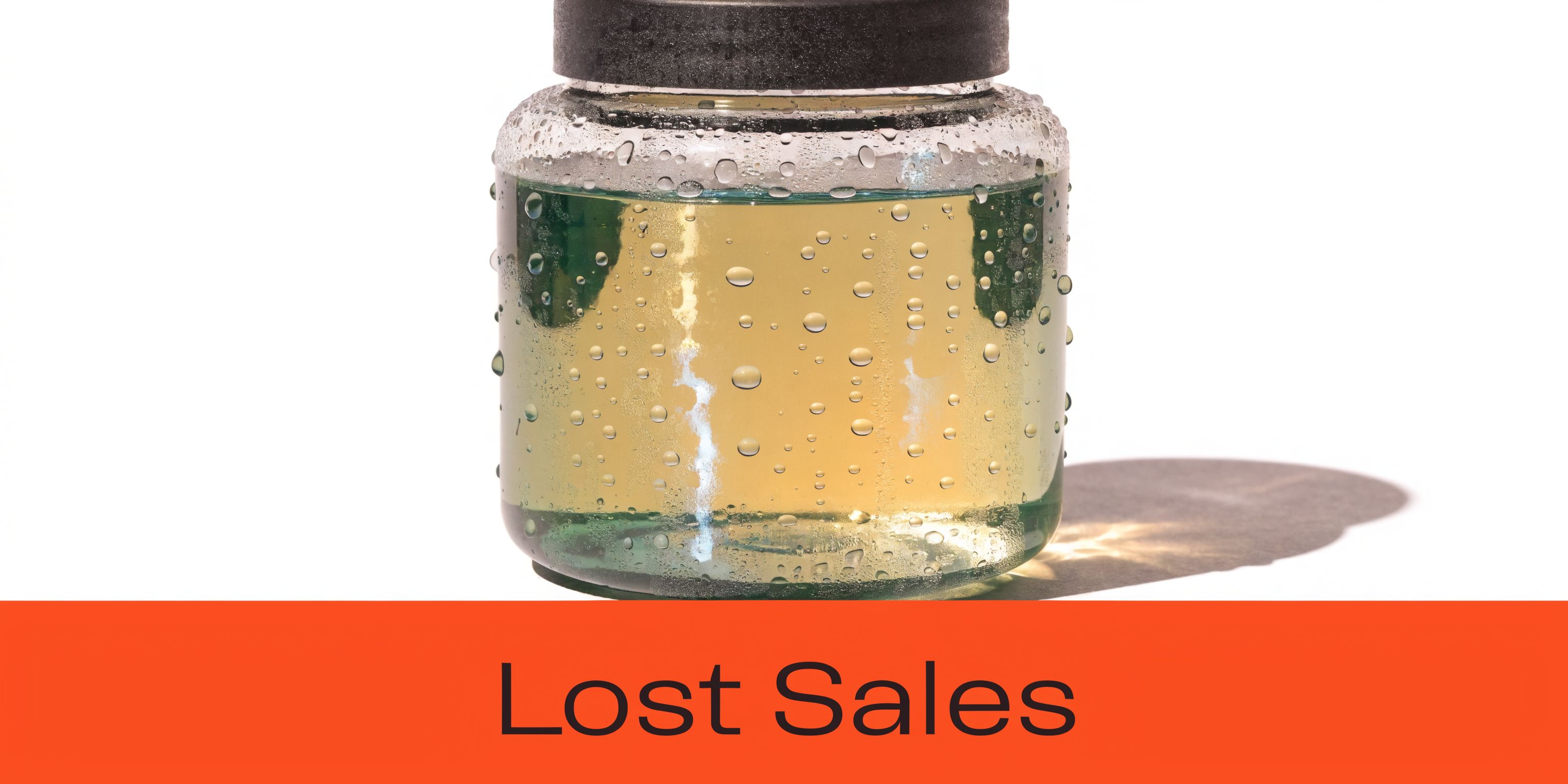 A glass jar filled with yellowish liquid and water droplets on its surface against white background.
